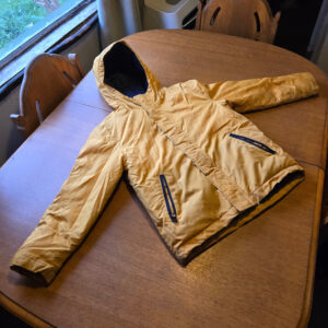 A yellow winter jacket for boys with a navy blue interior and zippers. The jacket is lightly used and has a few light marks on it. Size M(8). Created by Old Navy.